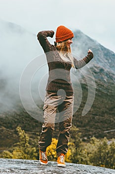 Happy woman walking alone in foggy mountains