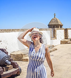 A happy woman walking along an antique Latinamerican marina promenade