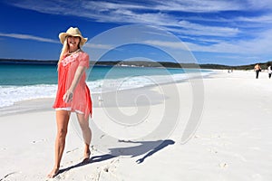 Happy woman walking along beautiful beach