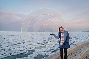 Happy woman walking along ice floes on lake michigan in Chicago