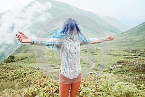 Happy woman walking in summer mountains.