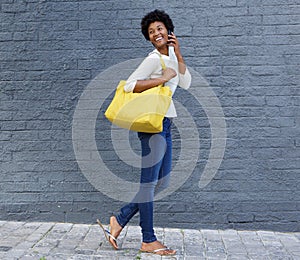 Happy woman walking and talking on mobile phone