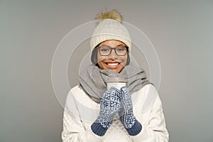 Happy woman in warm hat, mittens hold paper coffee cup drink hot chocolate or tea from takeaway mug