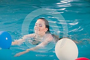 Happy woman in water having fun with balloons