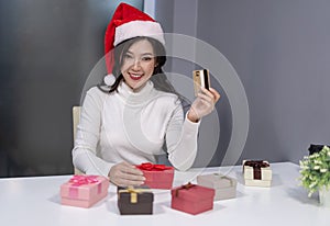 Happy woman wear santa hat holding credit card and christmas gif