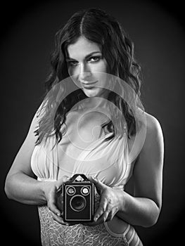 Happy woman wearing lingerie holding retro camera