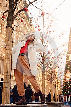 Happy woman in wearing white stylish warm clothes, sunny day. Concept winter holidays christmas europe city