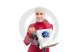 Happy woman wearing winter clothes offering presents