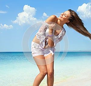 Happy woman in wet shirt on the beach