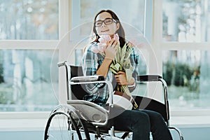 Happy Woman in Wheelchair with Flowers at Airport.