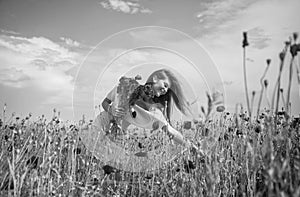 Happy woman in white dress on field of poppies at summer sunset, summer vacation