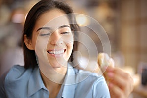 Happy woman with white smile looking at croissant