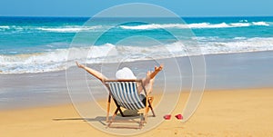 Happy woman in white sunhat on the beach