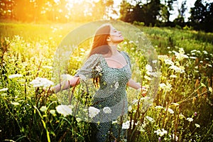 Happy woman among wildflowers on a summer day