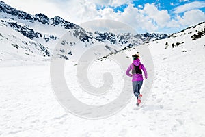 Happy woman winter trail running in beautiful inspirational land