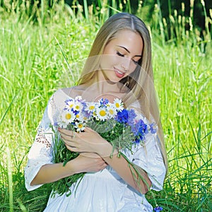 Happy woman wit bouquet of chamomiles and cornflowers