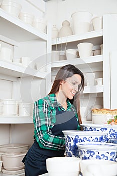 Happy woman working in a ceramics shop