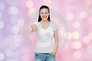 Happy womanin white t-shirt showing thumbs up