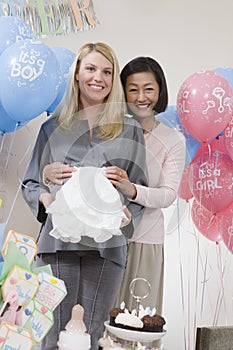 Happy Women With Baby Clothes At A Baby Shower