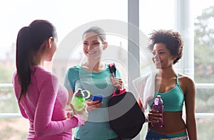 Happy women with bottles of water in gym