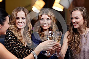 Happy women with champagne glasses at night club