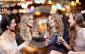 Happy women with champagne glasses at night club