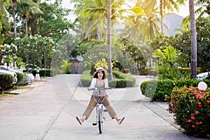 Happy women cycling spreads legs on bicycle at park,Practice pedaling circles,Riding a bike