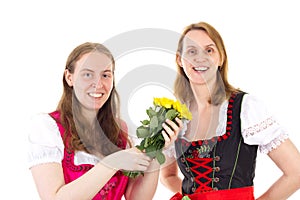 Happy women in dirndl with bunch of roses