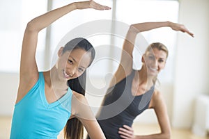 Happy Women Doing Stretching Exercise At Gym