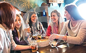 Happy women drinking beer at brewery restaurant - Female friendship concept with young girlfriends enjoying time together