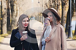 Happy women drinking cofee to go outdoors