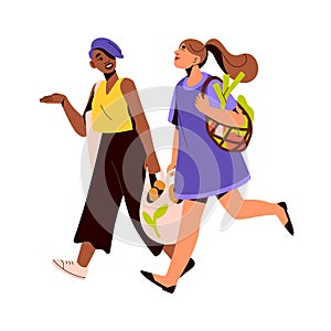 Happy women friends carrying tote and mesh bags from grocery store, food market. Modern girls going, walking, talking