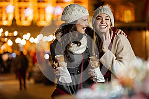 Happy women friends enjoying time together in the city with christmas decorations outdoor