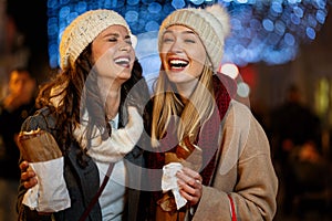 Happy women friends enjoying time together in the city with christmas decorations outdoor