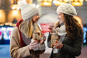 Happy women friends enjoying time together in the city with christmas decorations outdoor