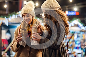 Happy women friends enjoying time together in the city with christmas decorations outdoor