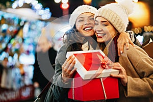 Happy women friends exchanging christmas present. Happiness people friend shopping xmas concept