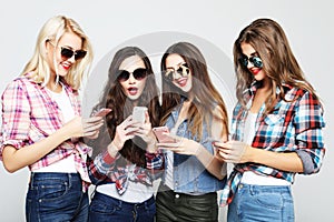 Happy women friends sharing social media in a smart phone