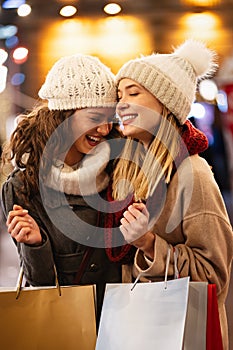 Happy women friends are shopping for presents at Christmas. People holiday sale shopping concept