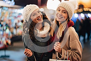 Happy women friends are shopping for presents at Christmas. People holiday sale shopping concept