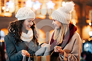 Happy women friends are shopping for presents at Christmas. People holiday sale shopping concept