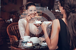 Happy Women Have Tea and Cake in Restaurant.