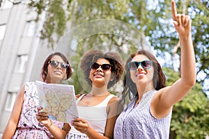 Happy women with map on street in summer city