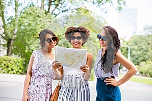 Happy women with map on street in summer city