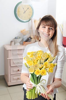 Happy women. narcissus beautiful flowers in womans hand. bouquet of delicate yellow color. the work of the florist at a