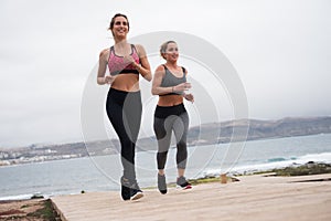 Happy women running on the boarwalk