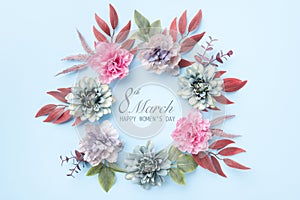 Happy Women`s Day Pastel Blue and Pink Colored Background. Flat lay floral greeting card with beautiful silk flowers.