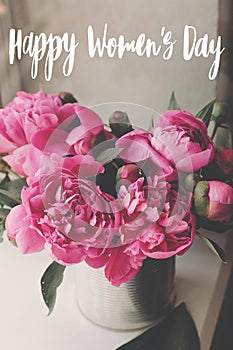 Happy Women`s day text. Happy Women`s day lettering on rustic stylish pink peonies . Floral greeting card.  Beautiful peony