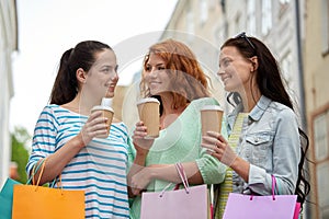 Happy women with shopping bags and coffee in city