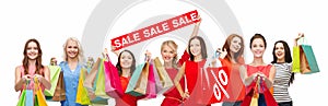 Happy women with shopping bags and sale sign